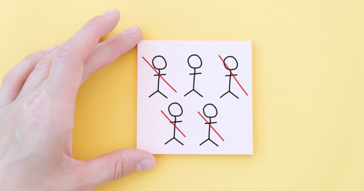 Sticky note with five simple stick figures; red diagonals cross out four of them, suggesting exclusion from the group.